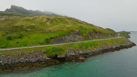 cinematic aerial shot of a van driving along a scenic road on the lofoten islands in norway, europe, drone