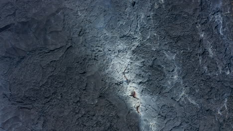 Spiral-down-aerial-birds-eye-overhead-top-down-view-of-black-grey-lava-fissure-crack,-Fagradalsfjall-Iceland,-day