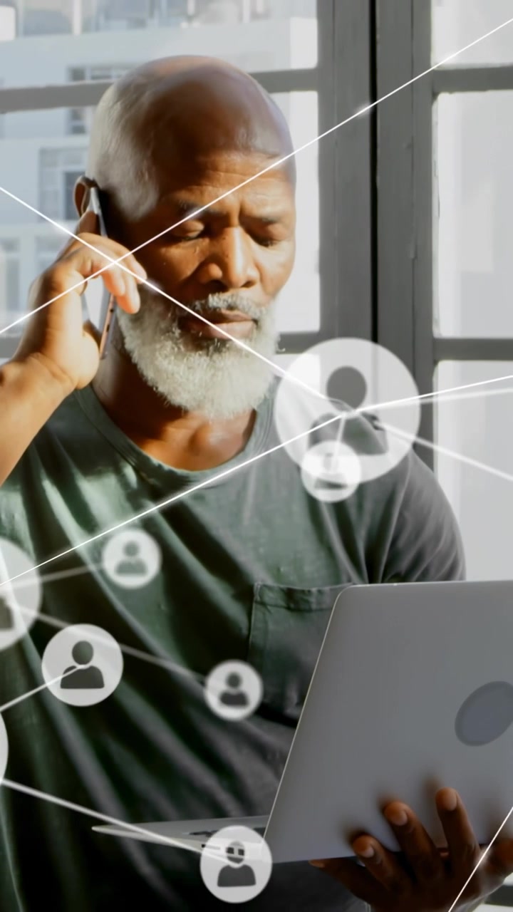 Vertical video: Senior man holding phone PC at window calling growing net icons over face for tech