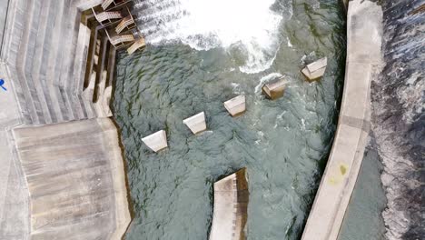 water cascading over dam spillway into river below