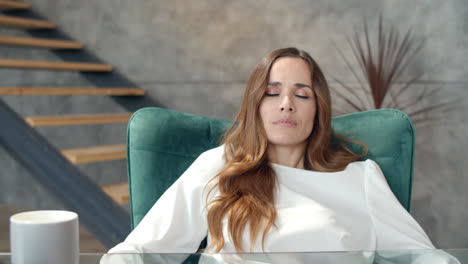 Young-business-woman-relaxing-on-chair-at-home-office.-Tired-girl-taking-break