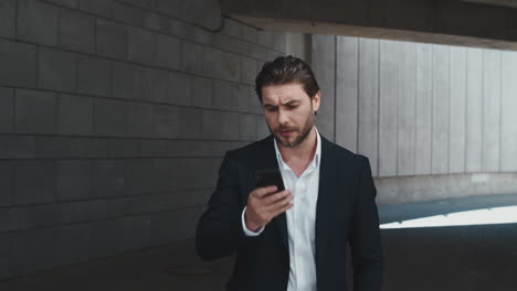 Business-man-arguing-in-smartphone-at-street.-Businessman-typing-on-cellphone