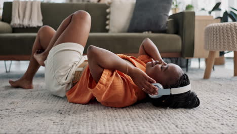 música, auriculares y mujer negra en el suelo