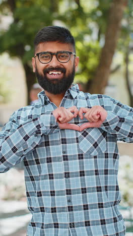 Indian-man-makes-symbol-of-love,-showing-heart-sign-to-camera,-express-romantic-positive-feelings