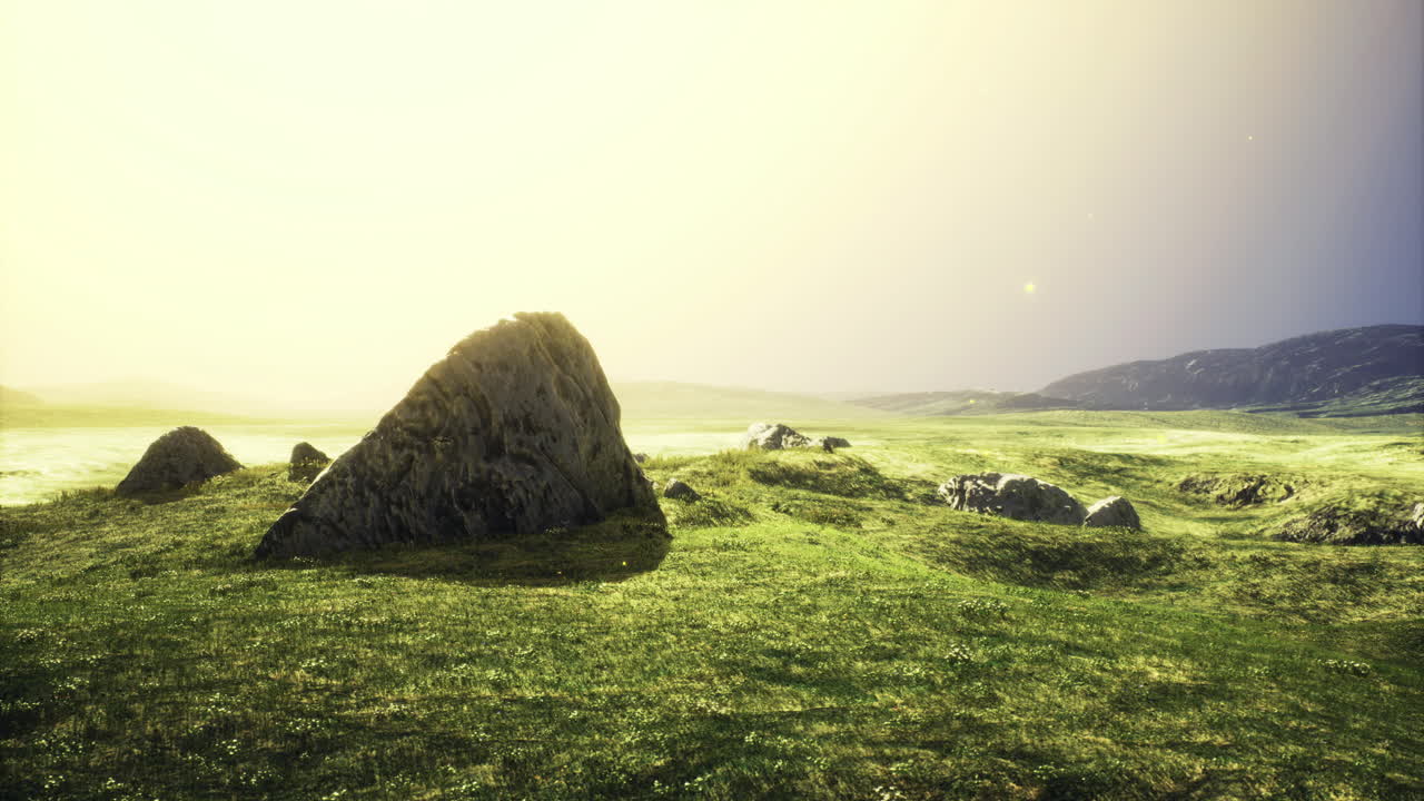 Vast green landscape with stones under gentle sunlight at dusk