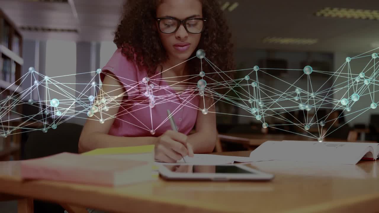 Woman student tapping tablet using book, writing study notes while faint network drifting over desk