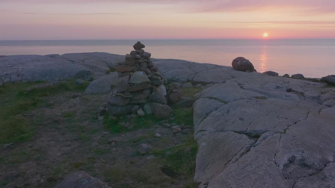 Sunset at Sheigra, Scotland. Camera pans left across a cairn with the glowing Atlantic horizon and rugged coastal rocks in view