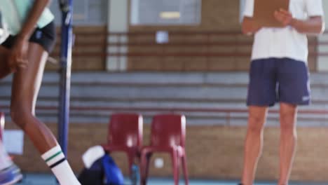 male coach assisting volleyball players in exercise 4k