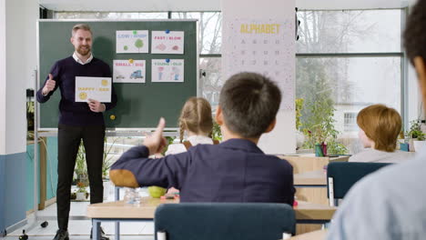 profesor enseña a un grupo de estudiantes multiétnicos las palabras 'feliz' y 'triste' en el aula de inglés 1