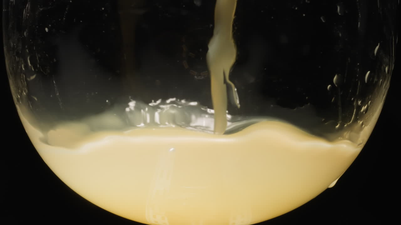 Fresh orange juice poured into glass splashing on sides