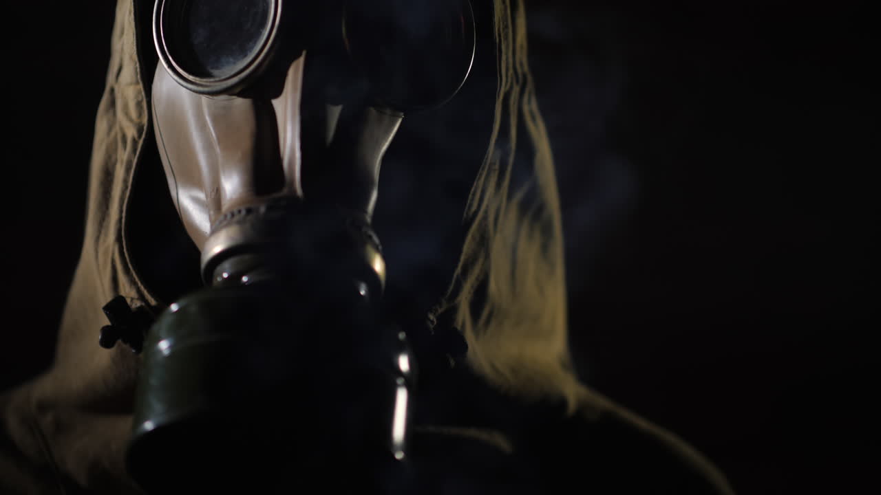 보호복을 입은 남자와 전경에서 방독면 연기