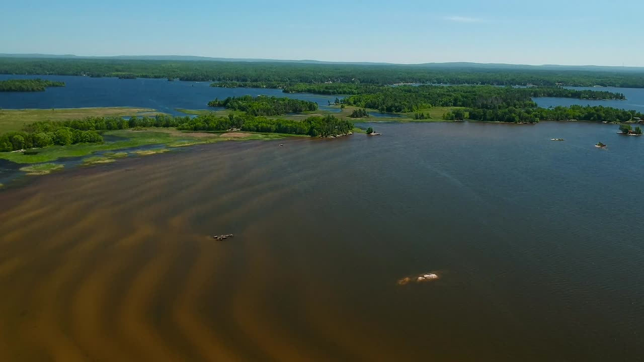 dron panorámico hacia abajo de un lago poco profundo con ondas de arena que se muestran en un hermoso y brillante día de primavera en north bay, canadá