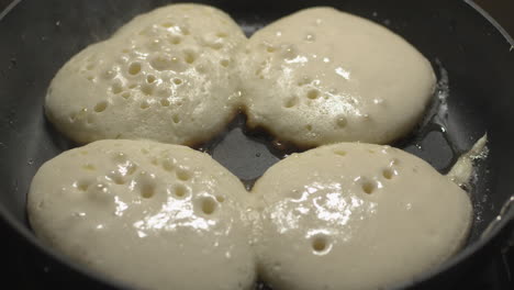 pancakes put and cooked in the frying pan for snacks time - close up shot