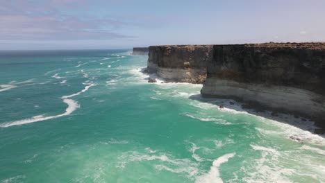 drone aéreo que se eleva con pan sobre la gran bahía australiana mostrando olas que se estrellan