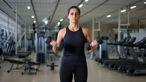 woman performing dumbbell curls in a gym