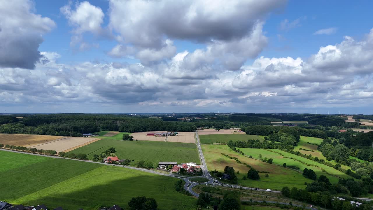 Picturesque American rural landscape with roundabout and traffic on streets. Agricultural farm fields near small village in Nebraska, USA. Aerial dolly wide shot. Clouds at sky in summer