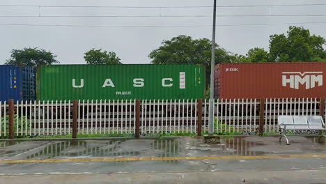 passing by a train station in indian village with vibrant freight train moving in background, rural transport and indian railway life during monsoon season.