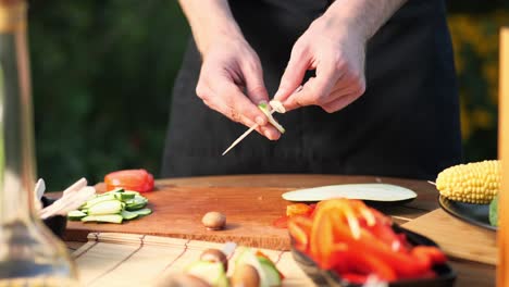 Cerca-De-Un-Joven-Preparando-Brochetas-De-Verduras-Para-Asar