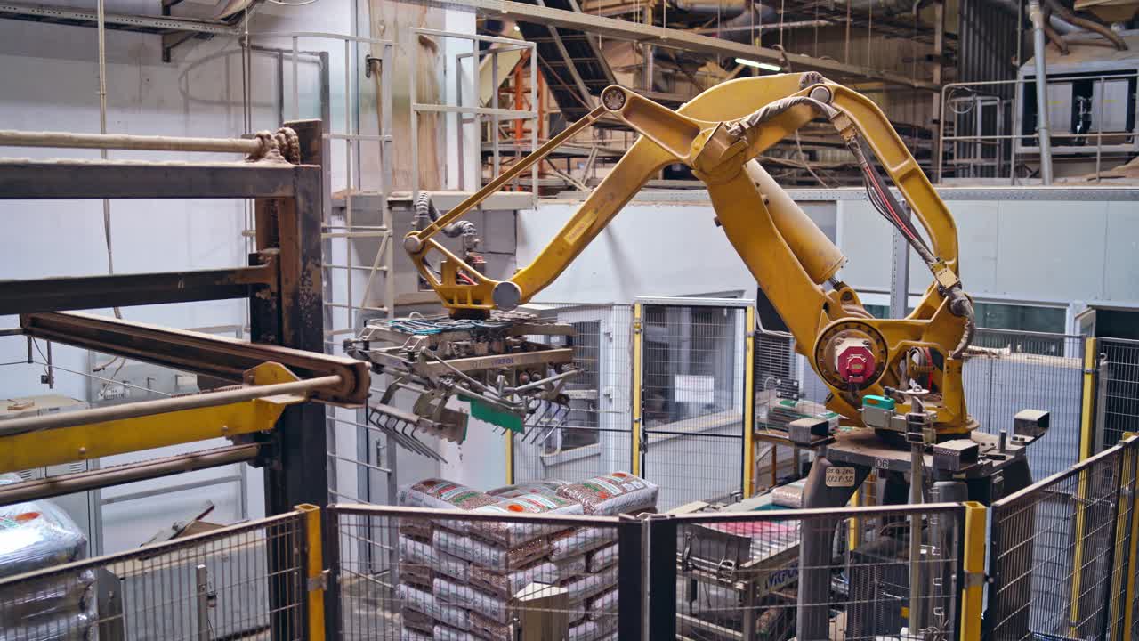 Industrial robotic machine in factory. Modern robot collects packed objects. Automated equipment at work.
