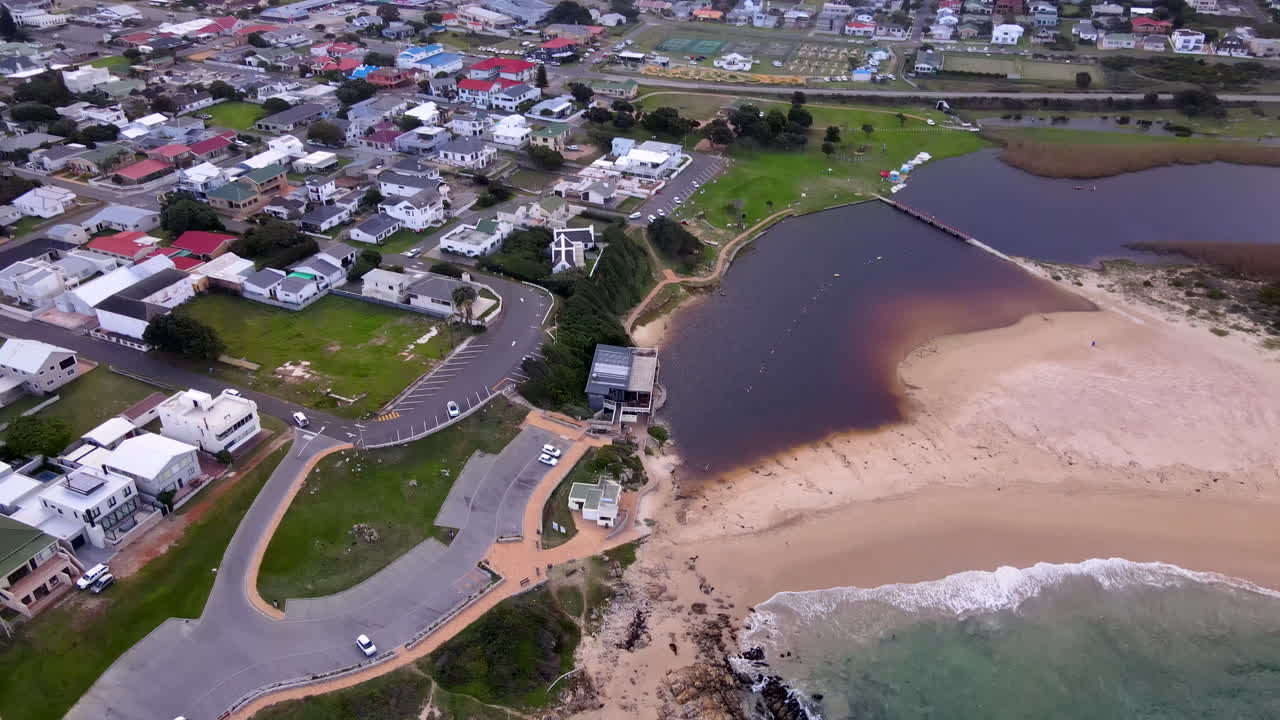 Tanin rich lagoon and Kleinmond coastal town next to mountain