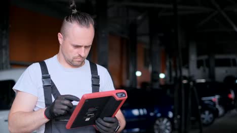 auto mechanic using a diagnostic tablet in a garage