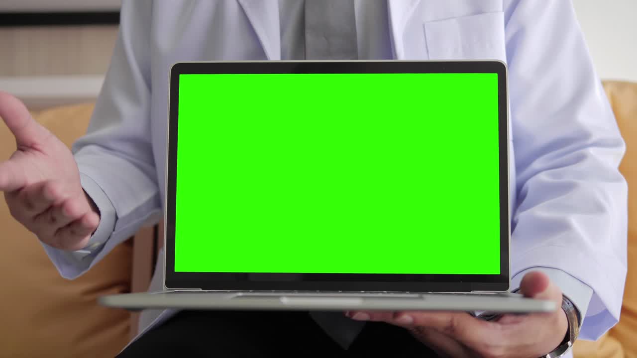 Medical doctor is explaining in white gown showing laptop with green screen