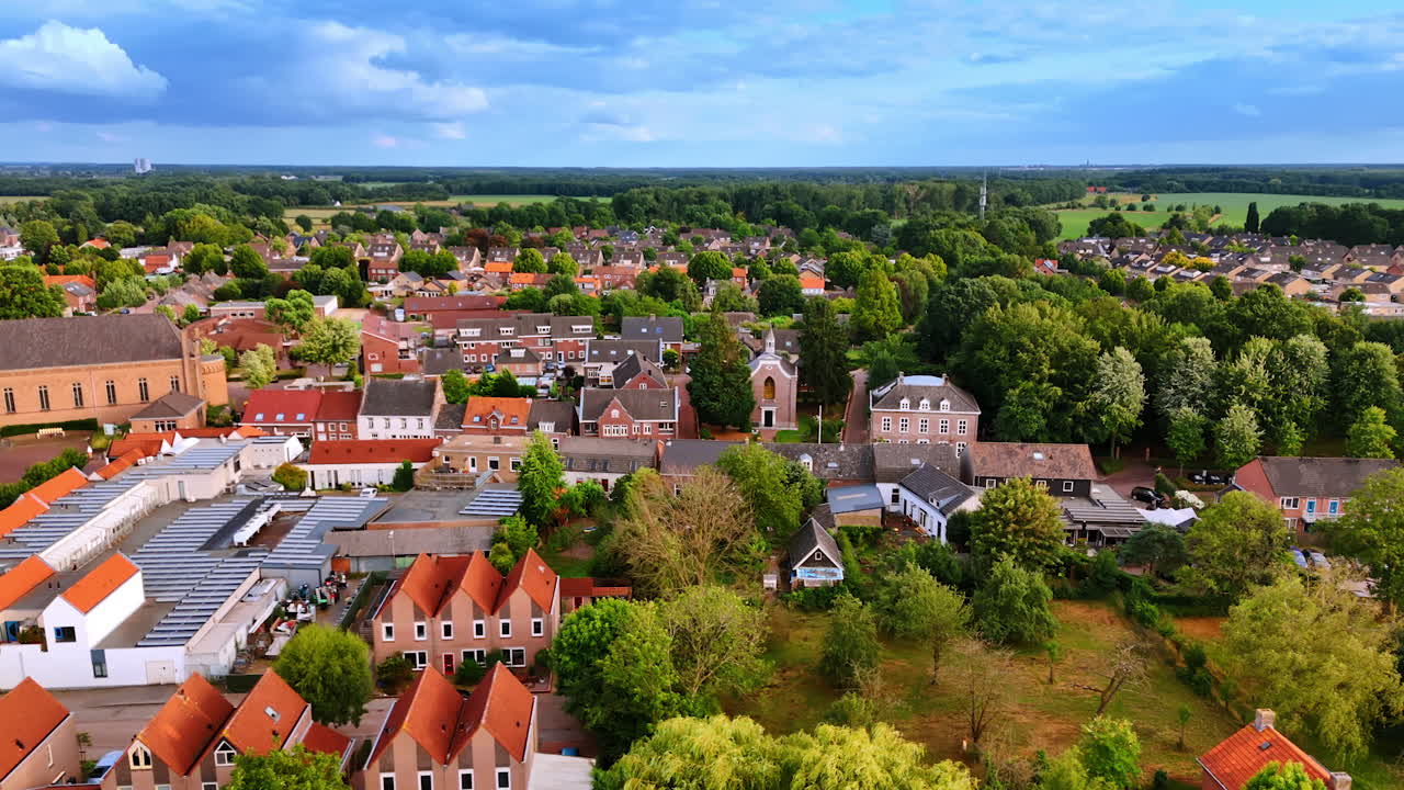 Drone view of Dutch village with church and traditional houses. Aerial drone photo of a Dutch village with a church, red rooftops, and surrounding greenery