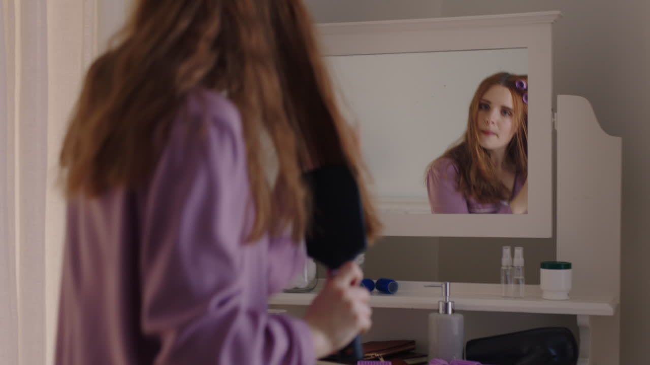 행복한 여성 침실에서 춤을 추고 머리카락을  ⁇ 고 주말을 준비하고 즐거운 아침을 즐기고 집에서 피자마를 입고 무관심한 라이프 스타일을 축하합니다.