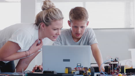 Estudiante-Varón-Con-Profesor-Construyendo-Un-Vehículo-Robot-En-Clase-De-Codificación-Informática-Después-De-La-Escuela