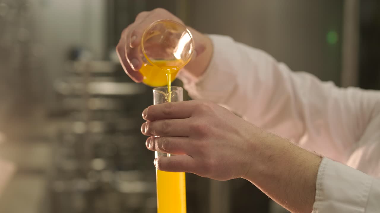 Vertiendo líquido naranja en un tubo de ensayo