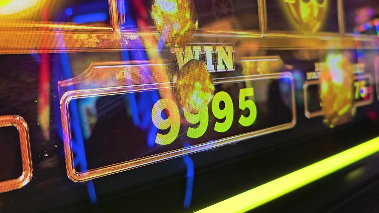 Schermo luminoso di slot machine da casinò che mostra un totale di crediti vincenti, monete d'oro, grafiche di coriandoli colorati, riflessi al neon e luci arcade incandescenti per video di intrattenimento sul gioco d'azzardo.