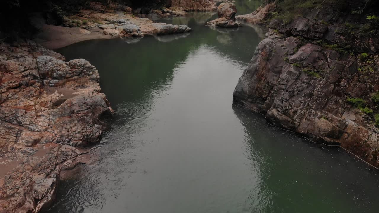 el río pacífico entre el valle verde y exuberante en un ambiente brumoso - toma aérea inclinada hacia arriba