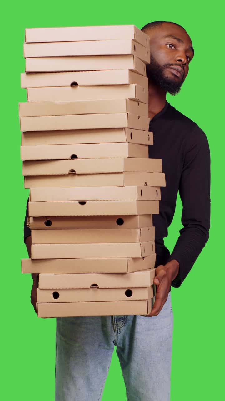 Video verticale: vista frontale di un uomo afroamericano che tiene in mano una pila di cartoni della pizza