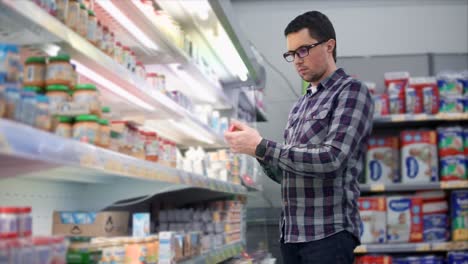 hombre comprando comida para bebés en una tienda de comestibles