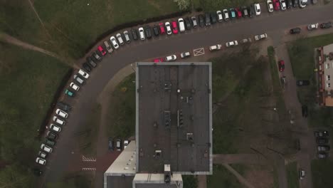un largo estacionamiento en un complejo de viviendas lleno de coches