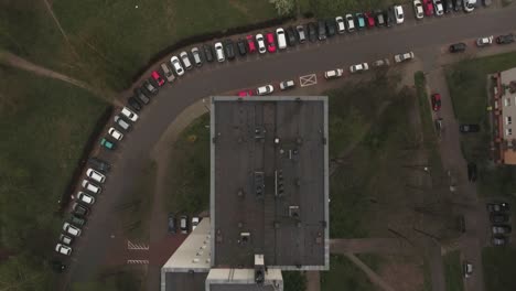 a long parking lot in a housing estate filled with cars