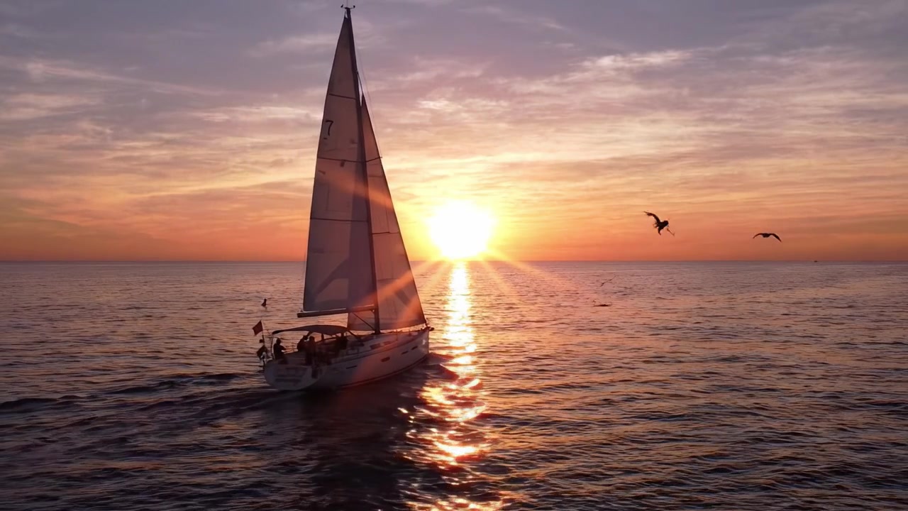 Uma Noite Cativante no Mar: Um Barco à Vela Desliza Pela Água Tranquila Sob um Pôr do Sol Deslumbrante, Iluminando o Céu com Cores Quentes do Crepúsculo