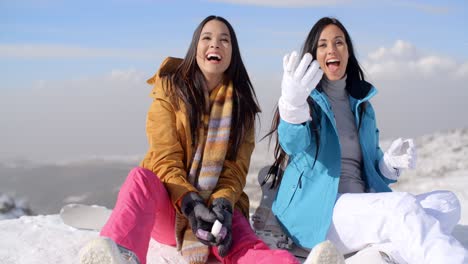 two gorgeous laughing young woman in snow