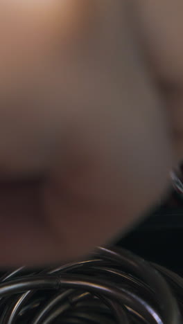 cu: experienced tailor hand takes round silver accessories from red box section in workshop extreme close view