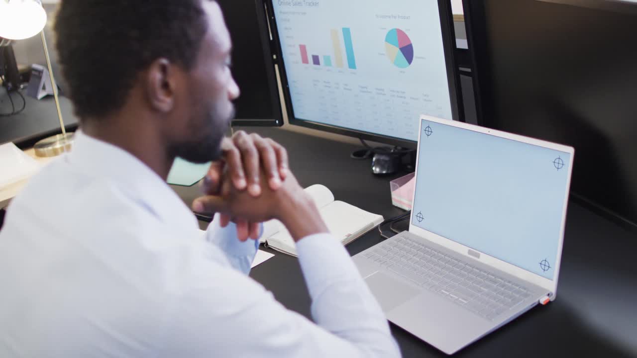 African american businessman using laptop with copy space in office, slow motion