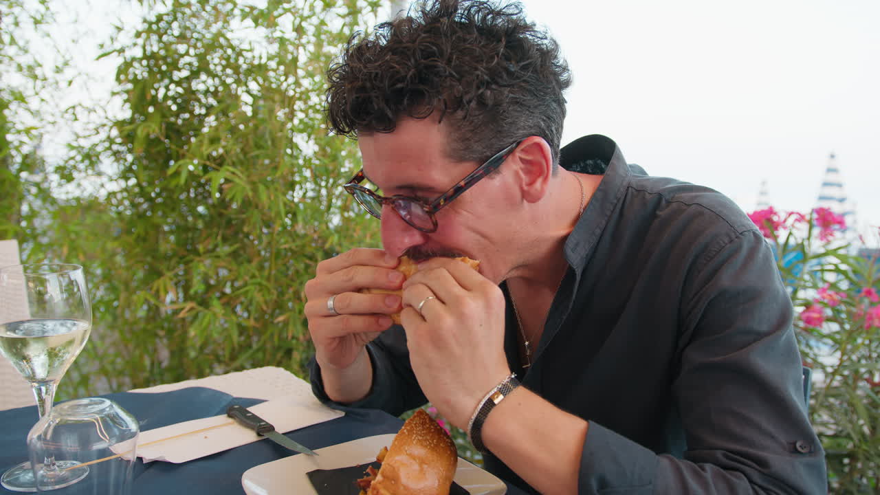 Man Enjoying The Burger For Lunch At The Restaurant On The Beach