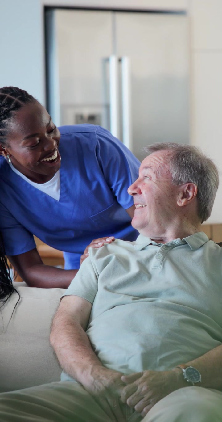Friendly Caregiver Comforting Senior Man at Home