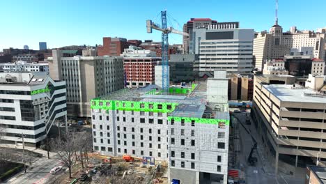 Aerial-shot-of-tower-crane-working-on-skyscraper-in-American-city