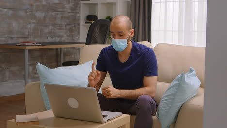 man with mask on a conference video call