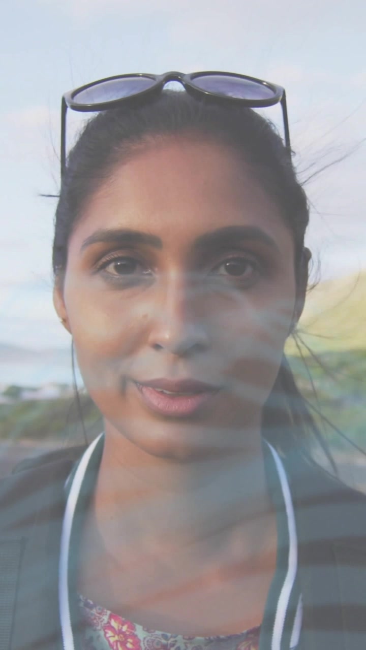 Vertical video: Woman smiling while camera zooming and lens flare sweeping face, making travel ad