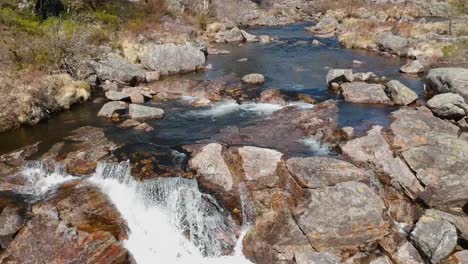 imágenes de drones volando hacia atrás por un pequeño río a principios de la primavera, la cámara apunta hacia abajo, sin cielo, sur de noruega, full hd 30p