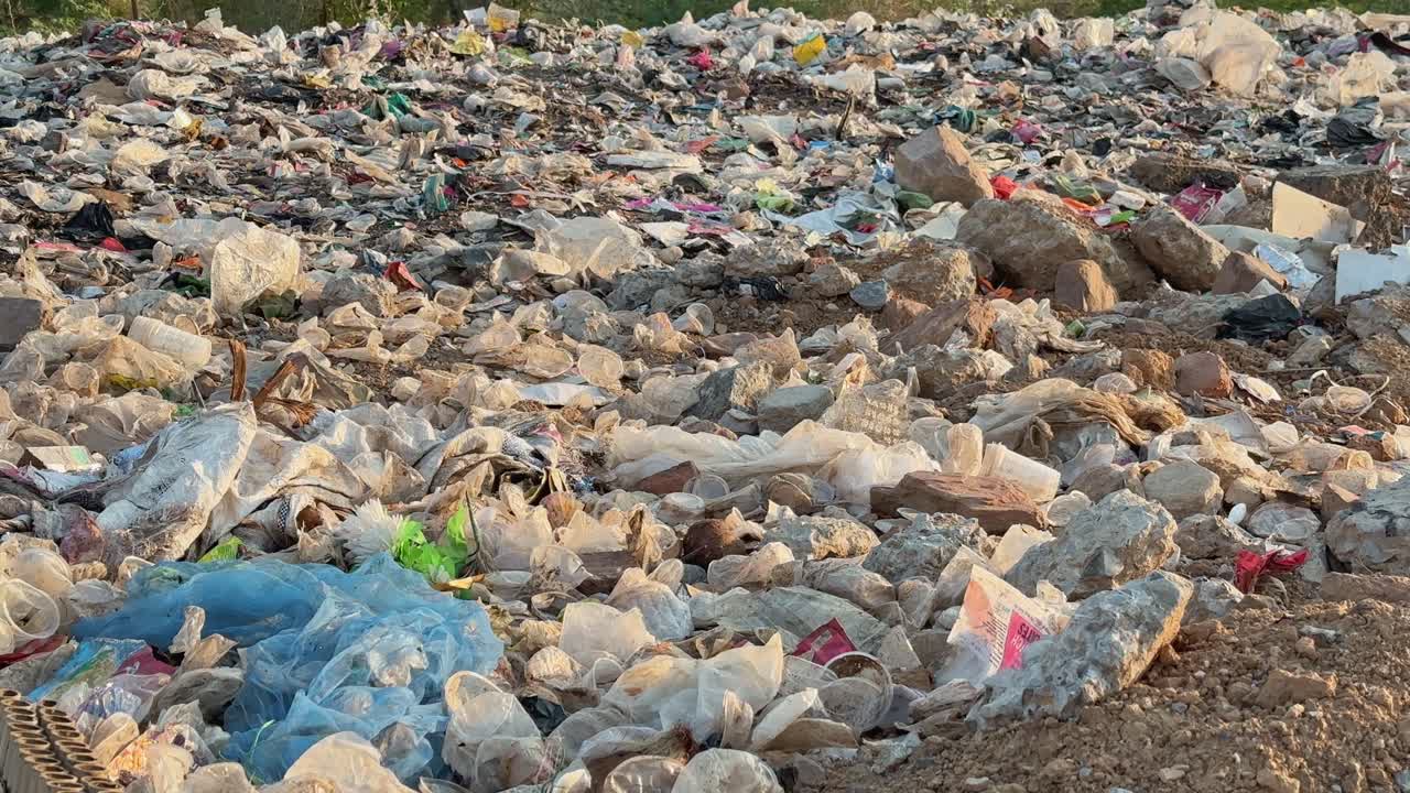 Plastic waste scattered arount the lanfill site at the dump yard, it is a serious environmental issue