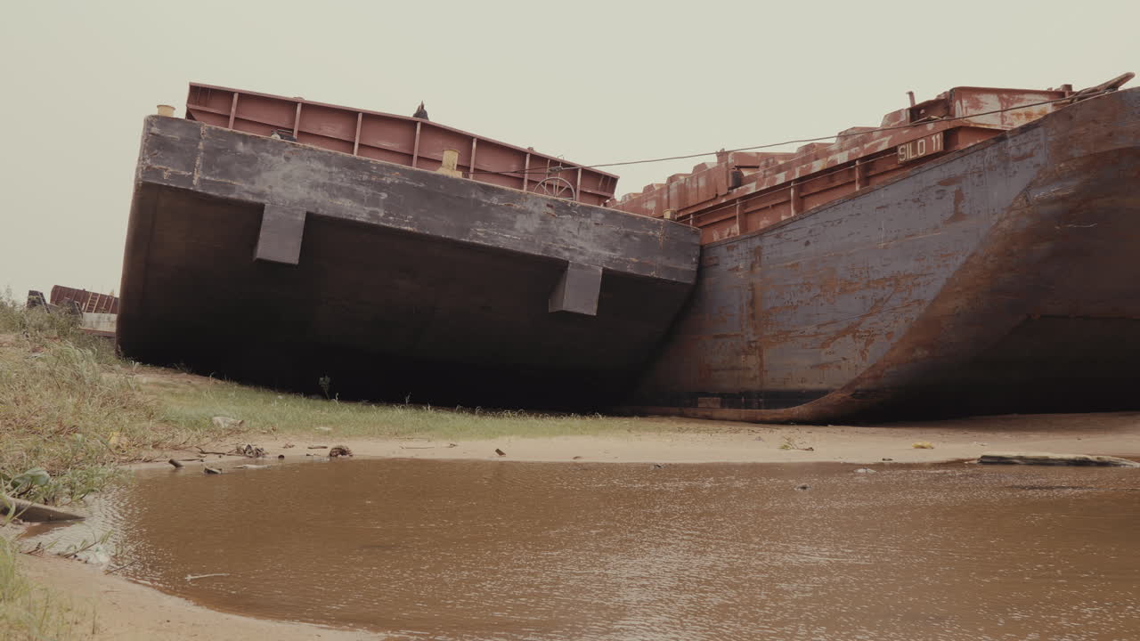 Rusting Abandoned Barges on Riverbank: Industrial Decay by the Water’s Edge. impact of time and abandonment on industrial structures