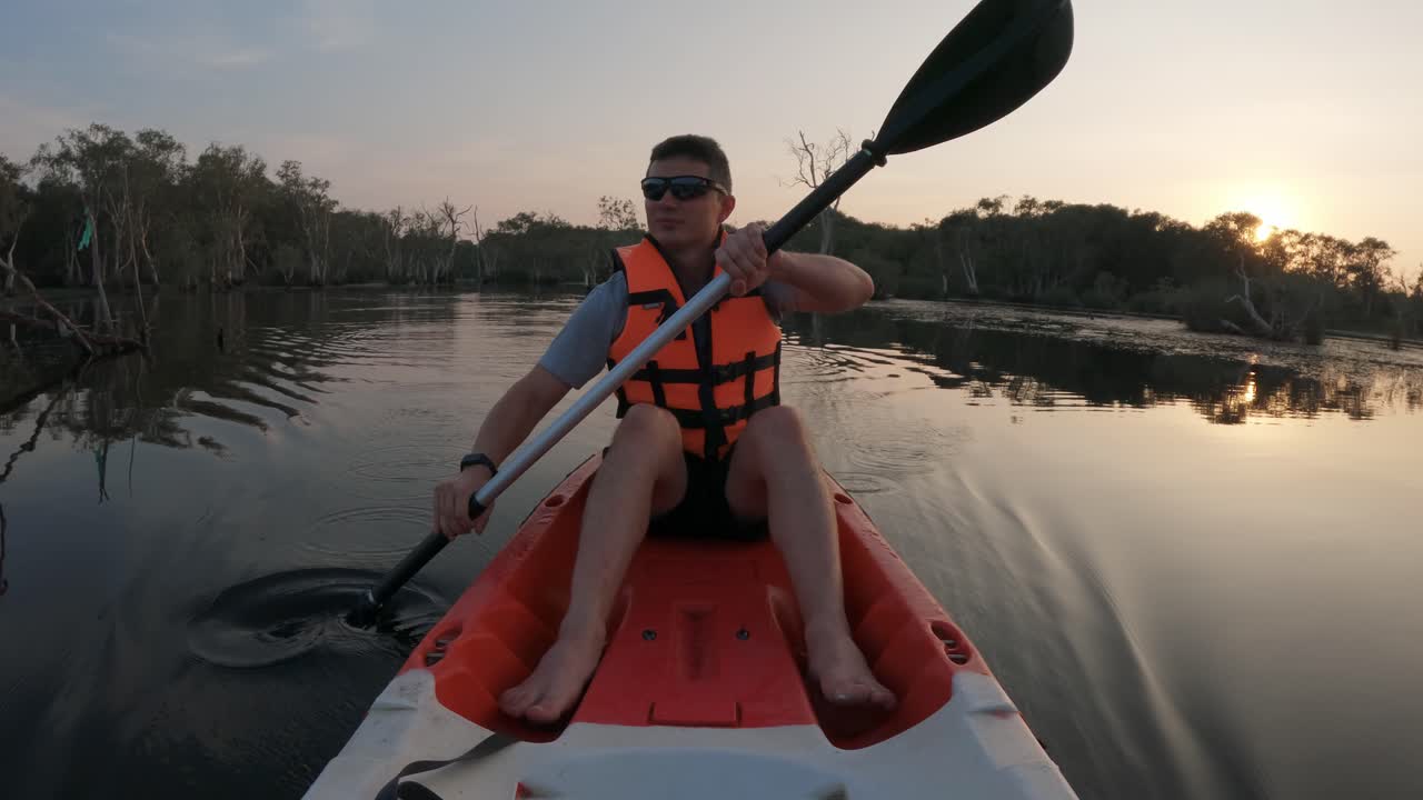 Front view of an adult man paddling in a kayak through a botanical garden or Mangrove forest - Thailand