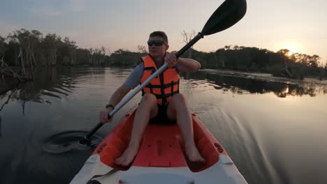 Front-view-of-an-adult-man-paddling-in-a-kayak-through-a-botanical-garden-or-Mangrove-forest---Thailand